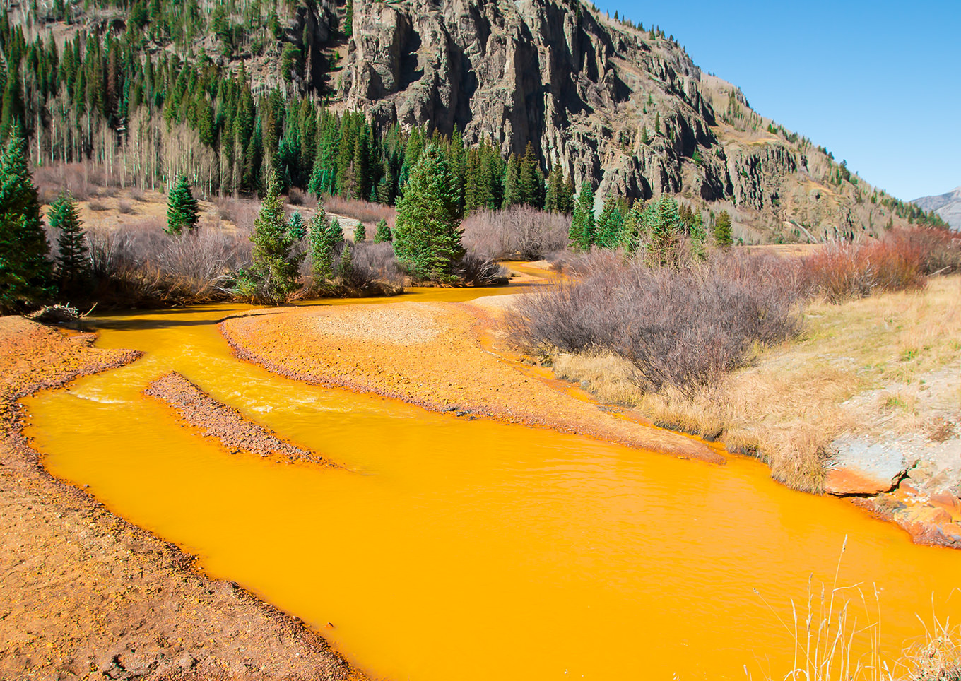Yellow-orange toxic waste in water on the mountain in Colorado, USA